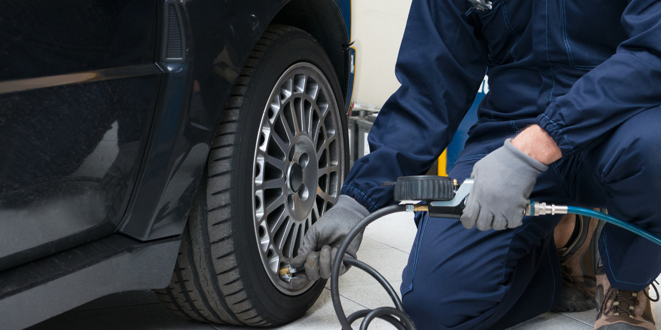Mechanic putting air in car tyres