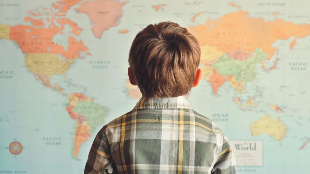 Boy looking at world map