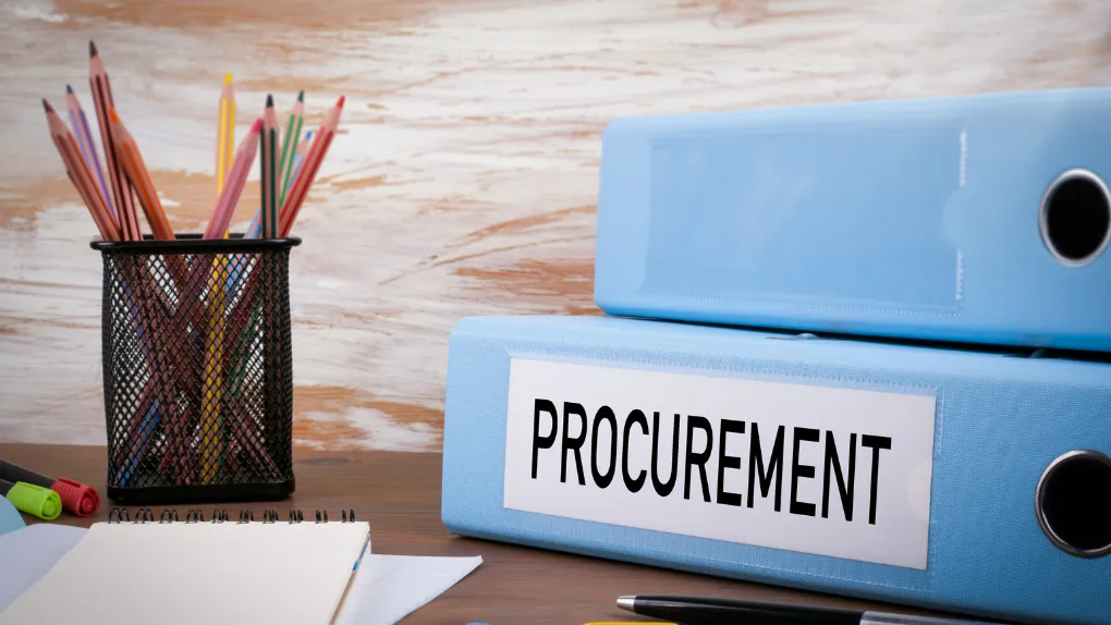 Desk with Procurment labelled folder and pot of pencils