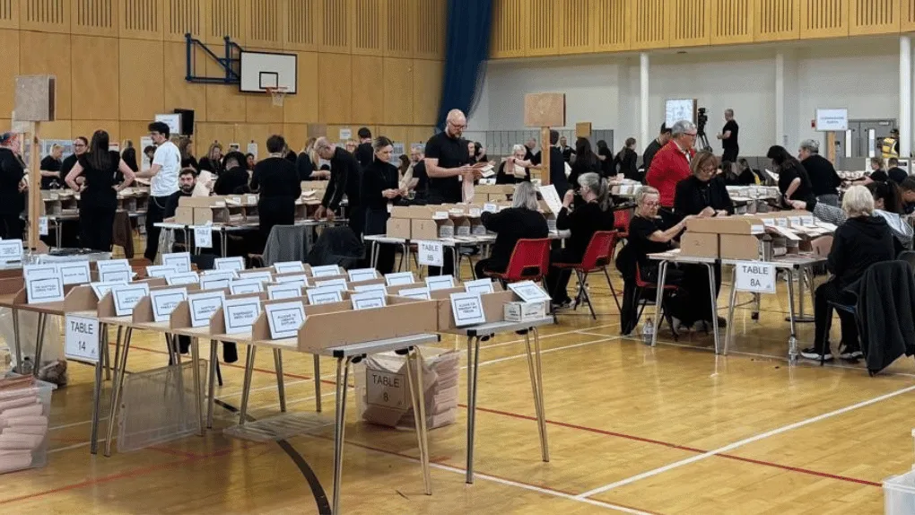 An election count with tables for ballot papers - and people working in the background