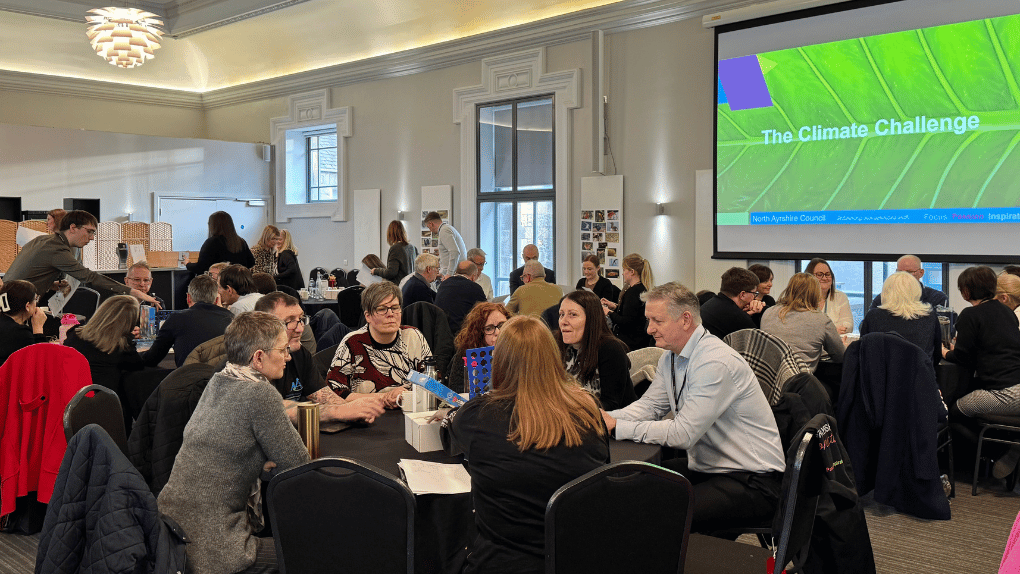 A group of more than 30 people gathered in a large room room
