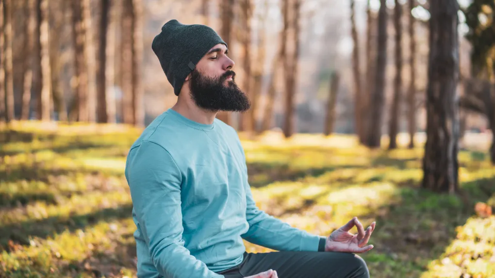 Person meditating in forest
