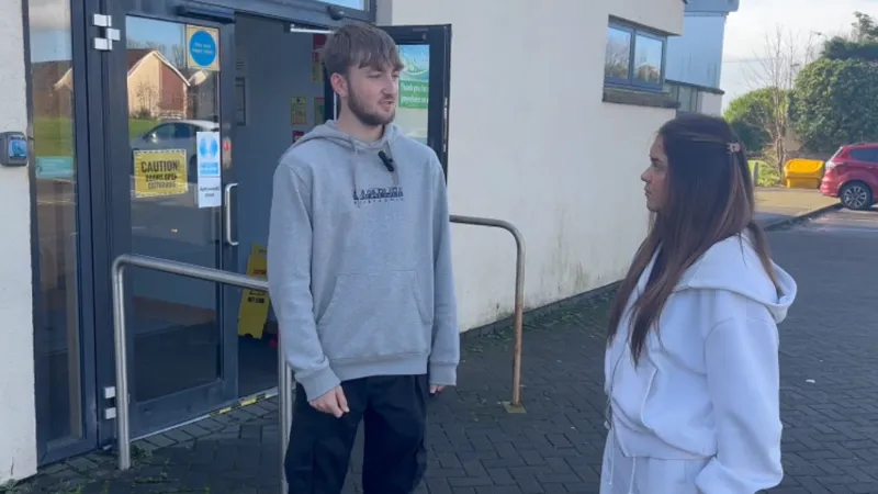 Two apprentices standing in conversation in front of a council building.